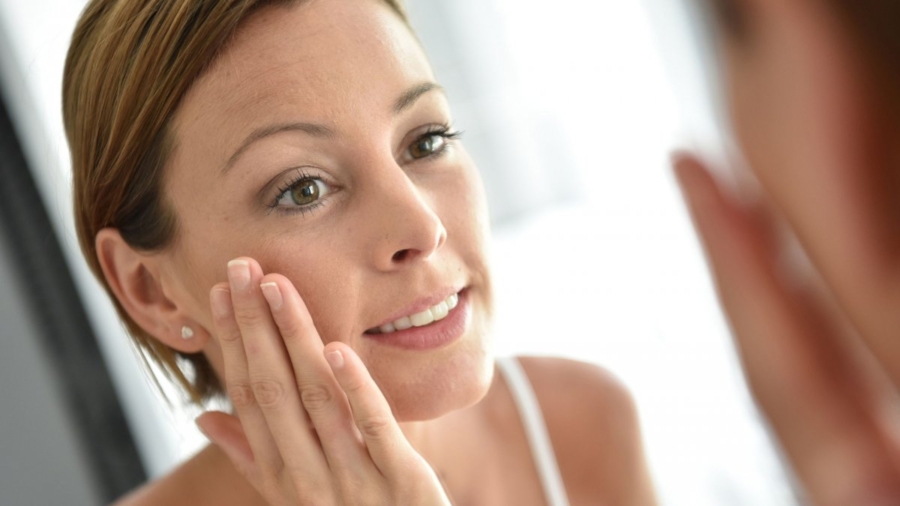 0f311935-bigstock-Woman-applying-facial-cream-on-113294099
